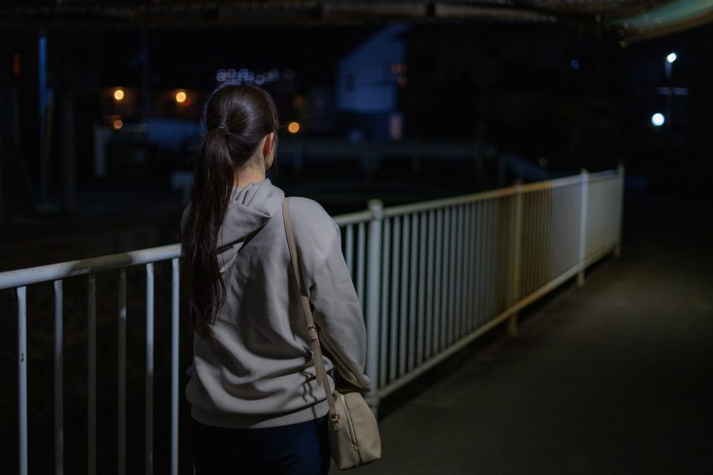 Woman walking down dark street