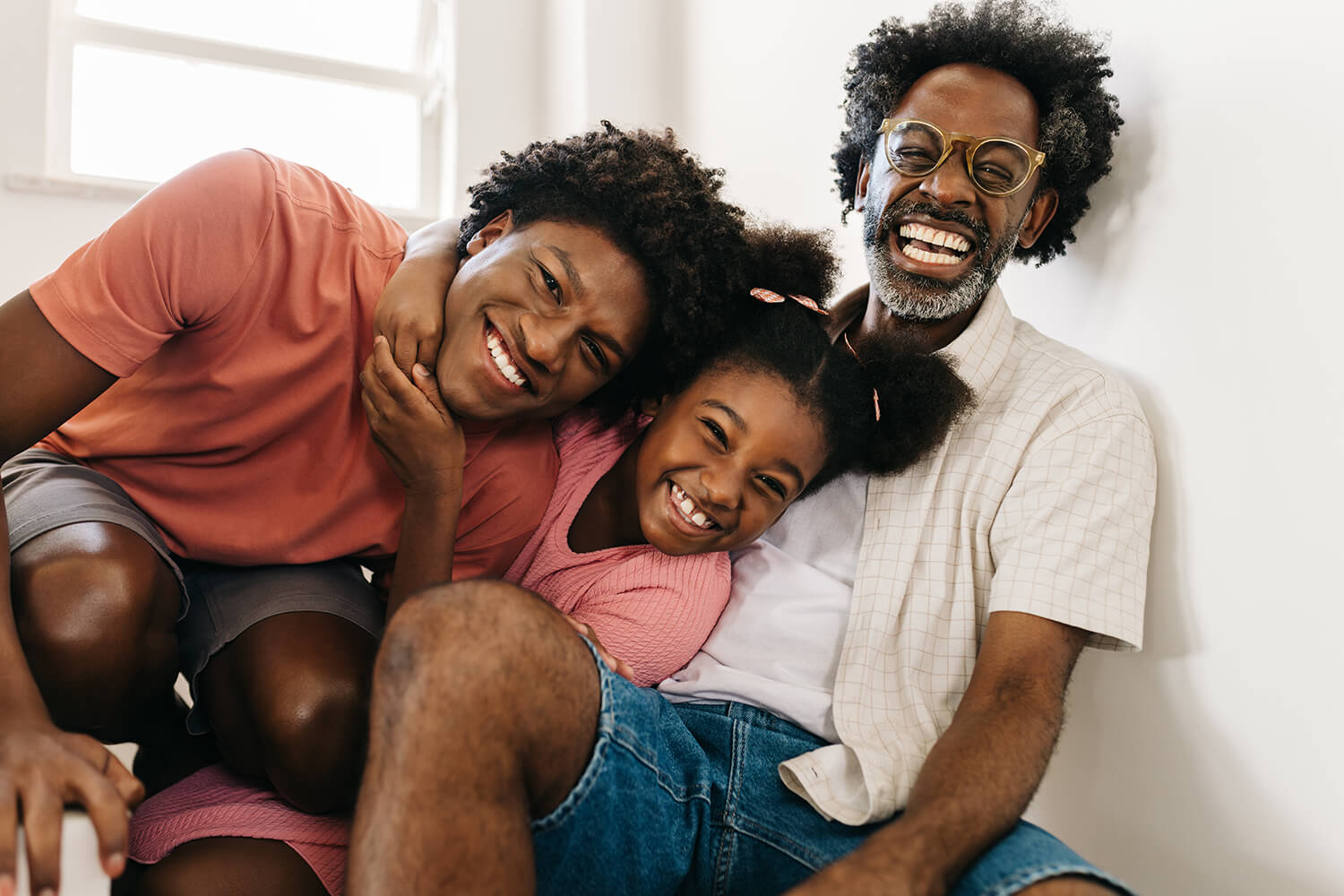 Father and two children smiling together, reflecting positive parenting and blended family support in Cheadle Hulme.