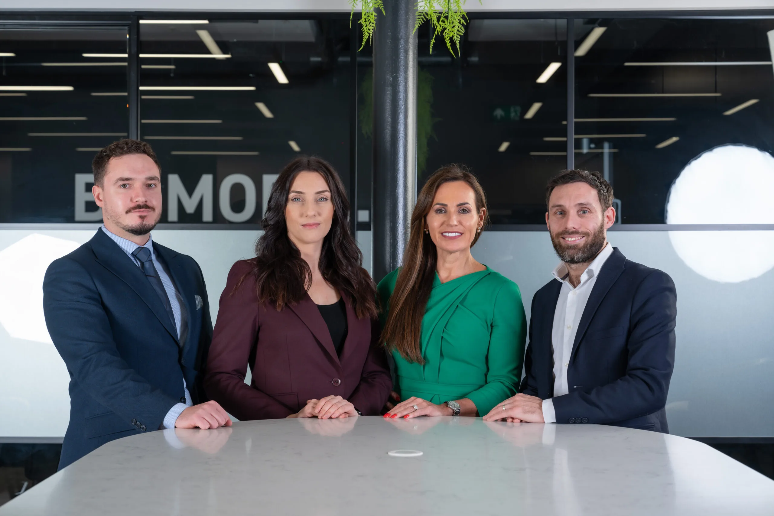 Professional legal team posing together in a modern Manchester law office setting.